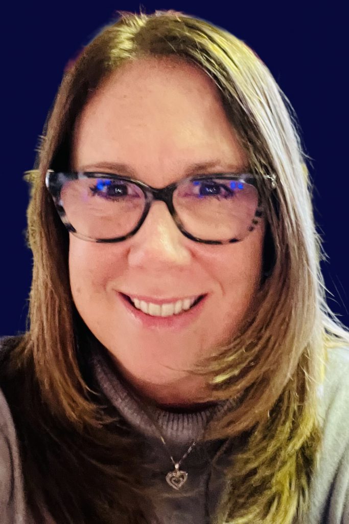 Headshot of deborah degraw, a smiling woman with straight blonde hair and glasses.