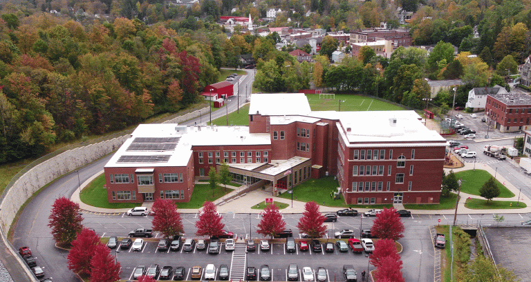 liberty elementary school, brick building with trees surrounding the building, cars in parking lot