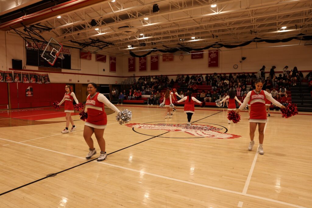 The Liberty cheerleading team performing for the crowd inside the gymnasium.