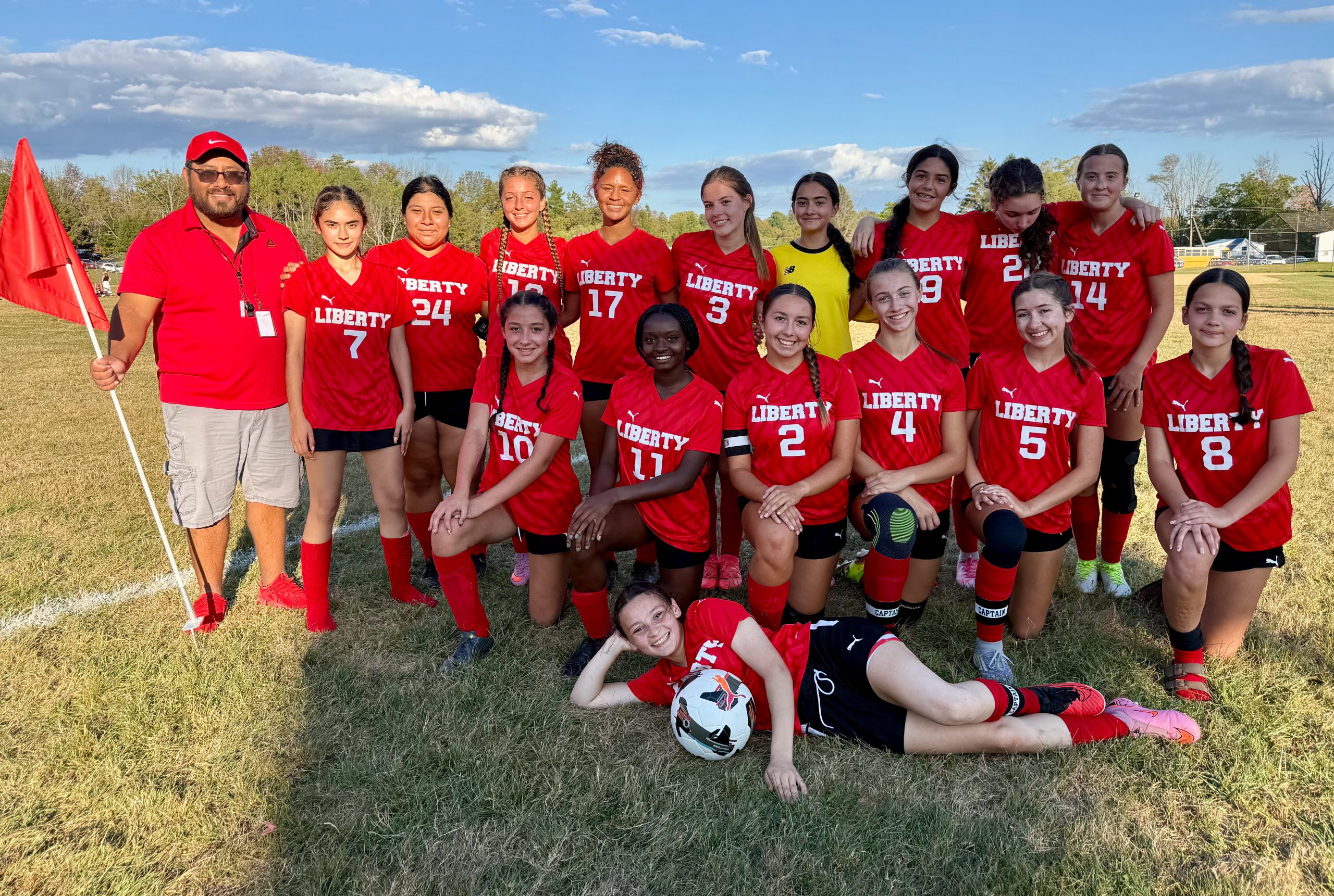 Students posed together on soccer field.