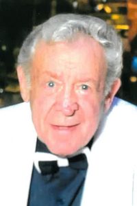 maurice gerry, alumni of liberty and honoree of wall of fame, facing camera, smiling, blue eyes, white suit jacket and bow tie
