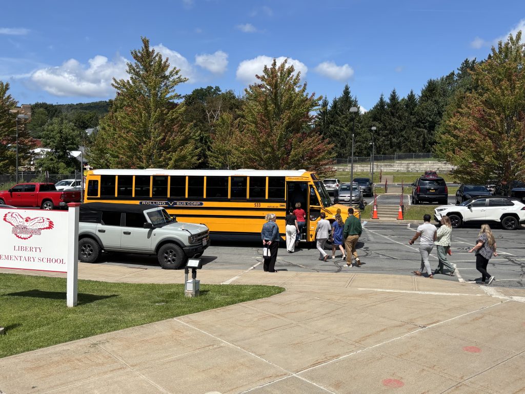 school bus and car in the parking lot, people heading to the bus
