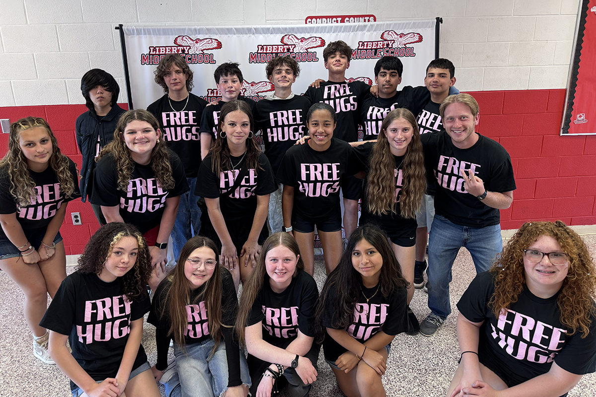 Students smiling together with Free Hug t-shirts on